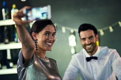 Buy stock photo Shot of a young woman taking a selfie with the bartender in a nightclub