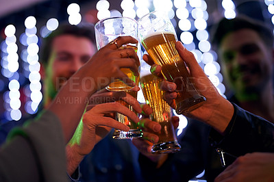Buy stock photo Shot of a group of young friends toasting with glasses of beer in a nightclub