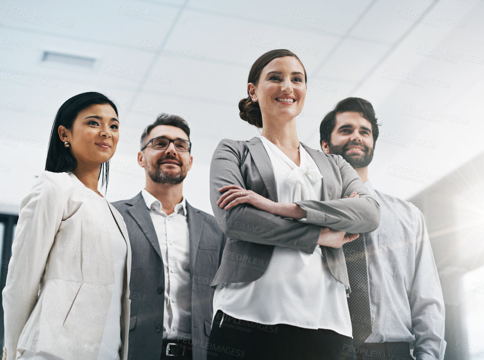 Buy stock photo Low angle shot of a group of businesspeople standing in the office