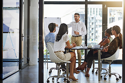 Buy stock photo Shot of a group of man giving a whiteboard presentation to colleagues in a boardroom