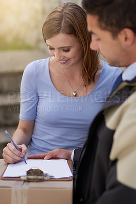 Buy stock photo Shot of a handsome young delivery man making a delivery to a customer at her home