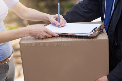 Buy stock photo Shot of an unidentifiable woman signing for the delivery of a package
