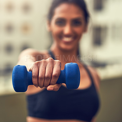 Buy stock photo Cropped shot of a young woman working out with dumbbells