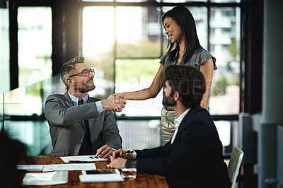 Buy stock photo Shot of two businesspeople shaking hands during a meeting in the boardroom