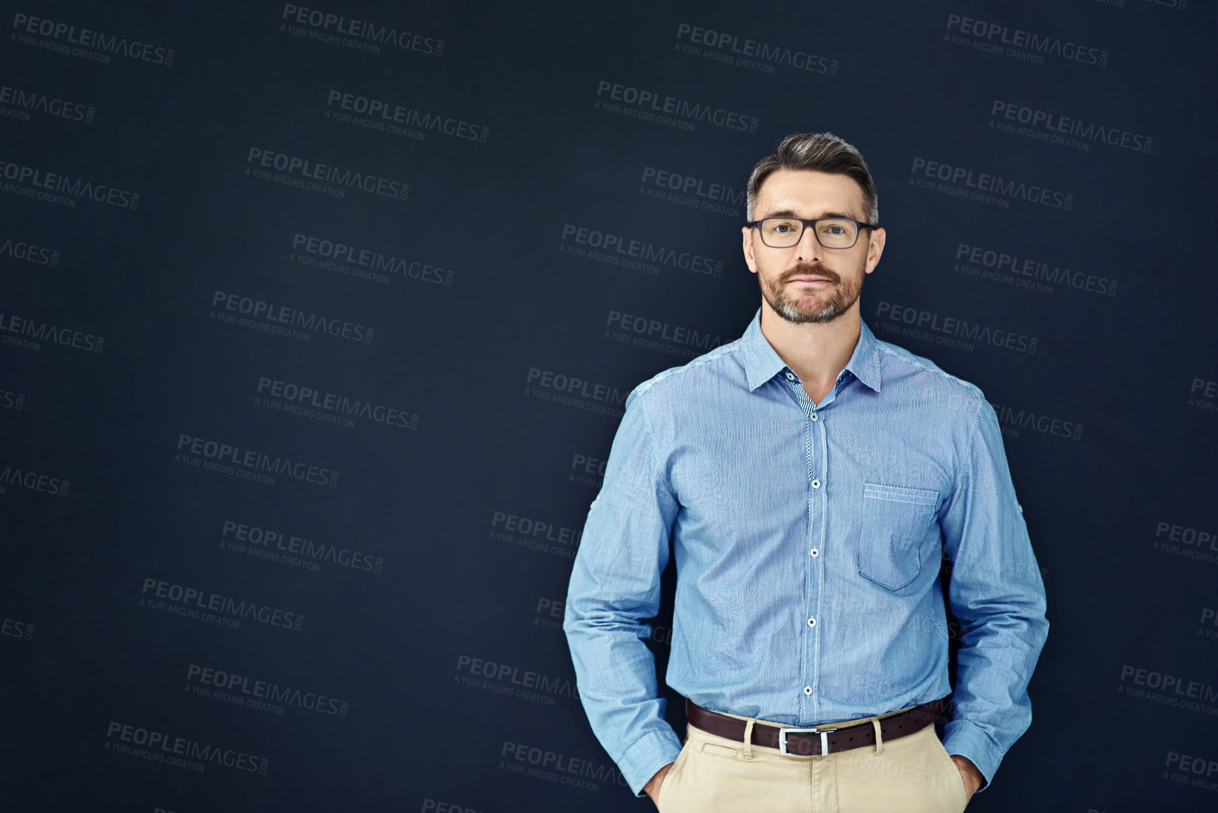 Buy stock photo Businessman, portrait and mockup in dark studio with employee isolated on blue background with glasses. Entrepreneur, career and about us for accounting company with confidence in New Zealand.