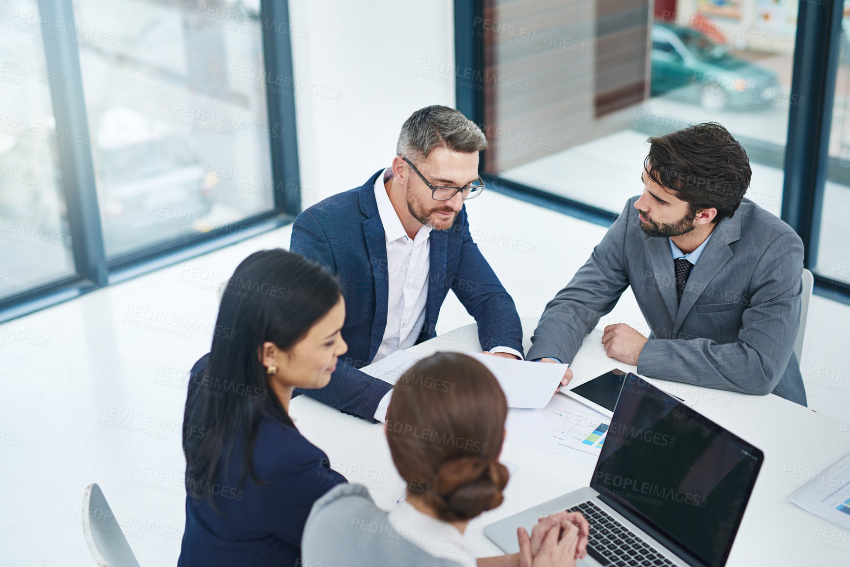 Buy stock photo High angle shot of a group of corporate businesspeople meeting in the boardroom