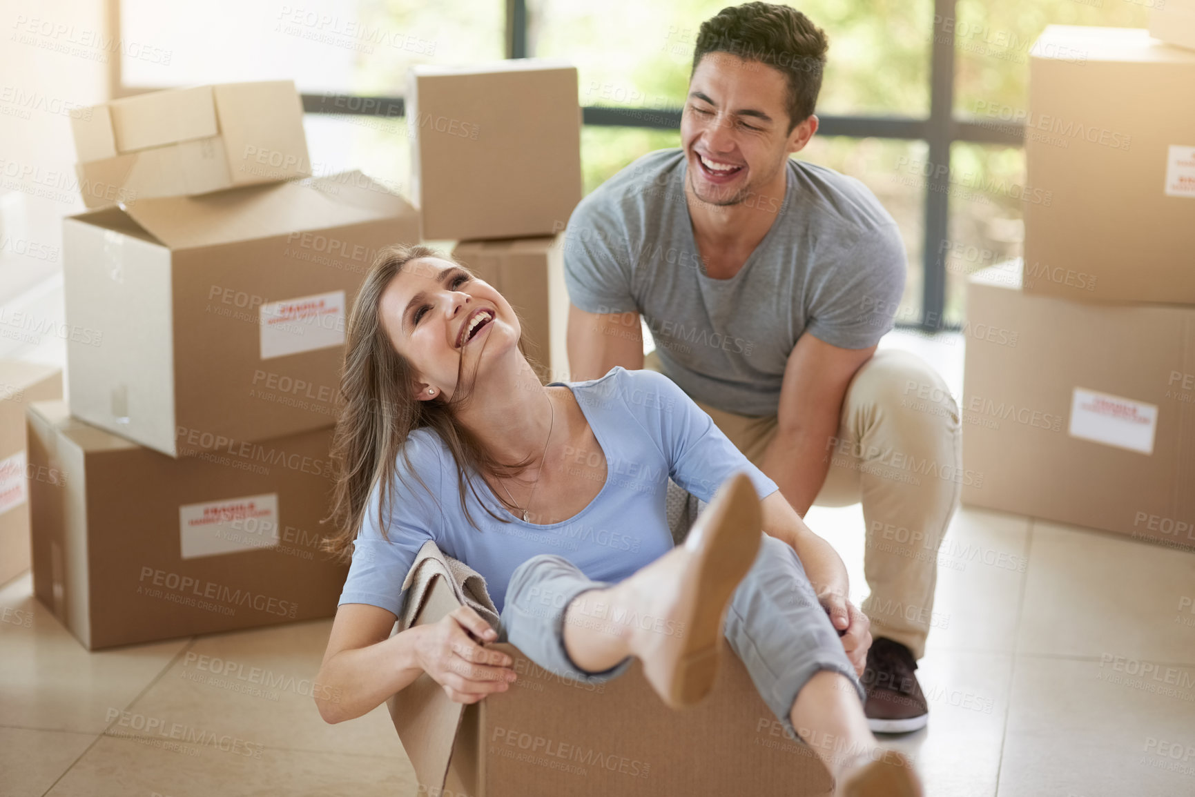 Buy stock photo Happy, couple and moving with boxes in new home for real estate, playing or together for growth. Man, house and woman in cardboard with smile for investment in future, property with mortgage in USA
