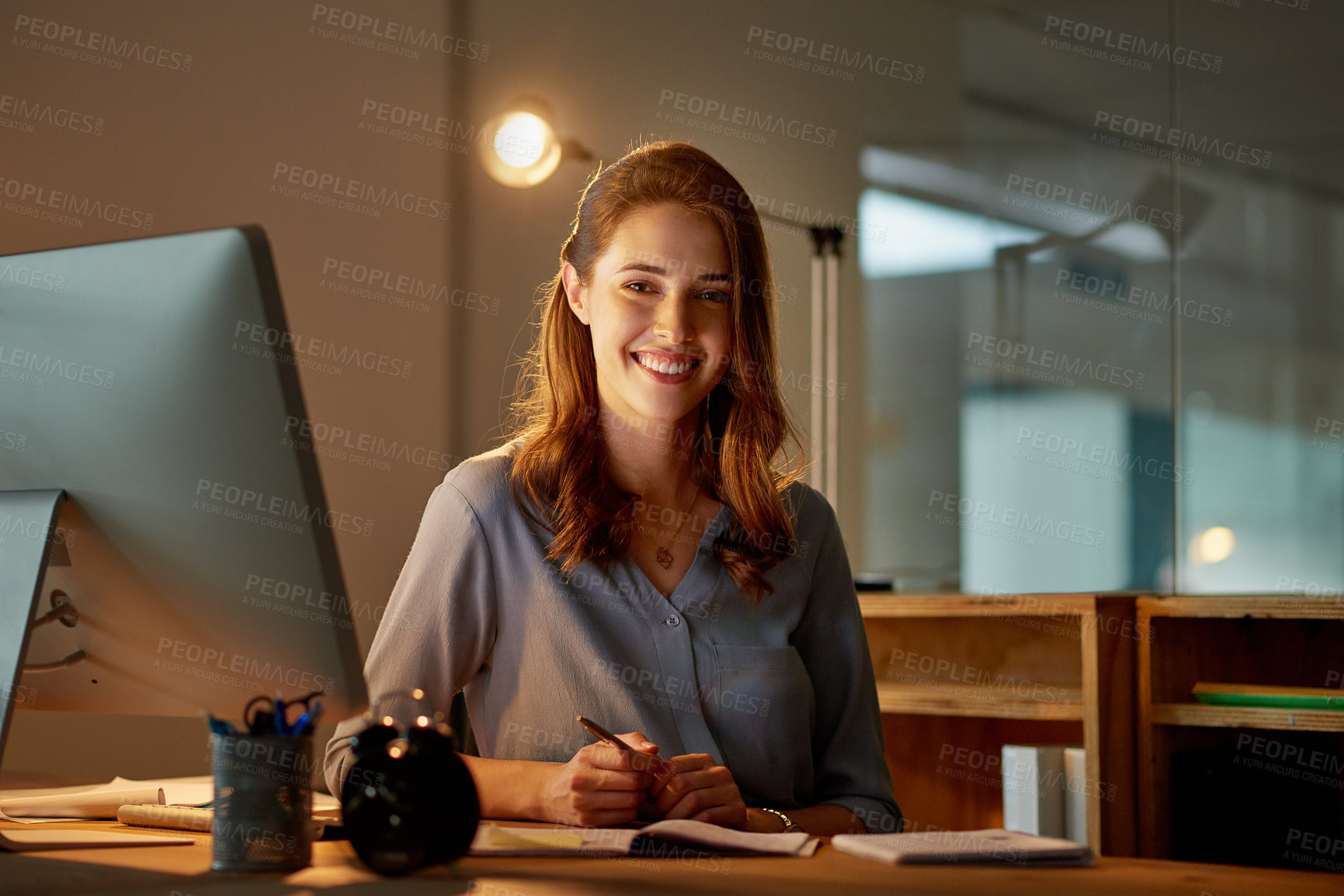 Buy stock photo Woman, employee and smile in office with computer on work break for overtime or deadline at night. Female person, portrait and worker with notepad as administrator for schedule, agenda and notes