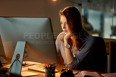 Buy stock photo Shot of an attractive young businesswoman working late in the office