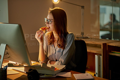Buy stock photo Shot of an attractive young businesswoman eating pizza while working late in the office