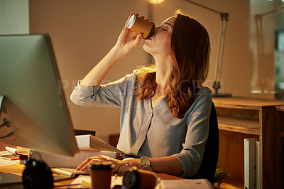 Buy stock photo Shot of an attractive young businesswoman drinking coffee while working late in the office