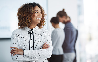 Buy stock photo Shot of a young businesswoman in the office with her colleagues in the background