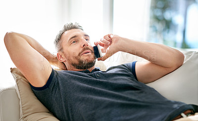 Buy stock photo Man, phonecall and smile for audio conversation, funny joke and good news on sofa in lounge. Young person, happy and mobile phone for talk, chatting or speaking for discussion and relax on weekend