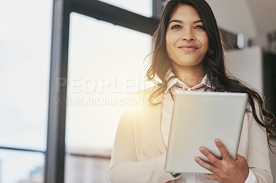 Buy stock photo Shot of a young businesswoman working on a digital table in an office