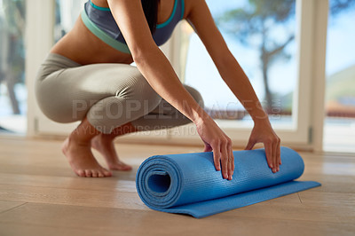 Buy stock photo Cropped shot of an unidentifiable woman rolling a yoga mat