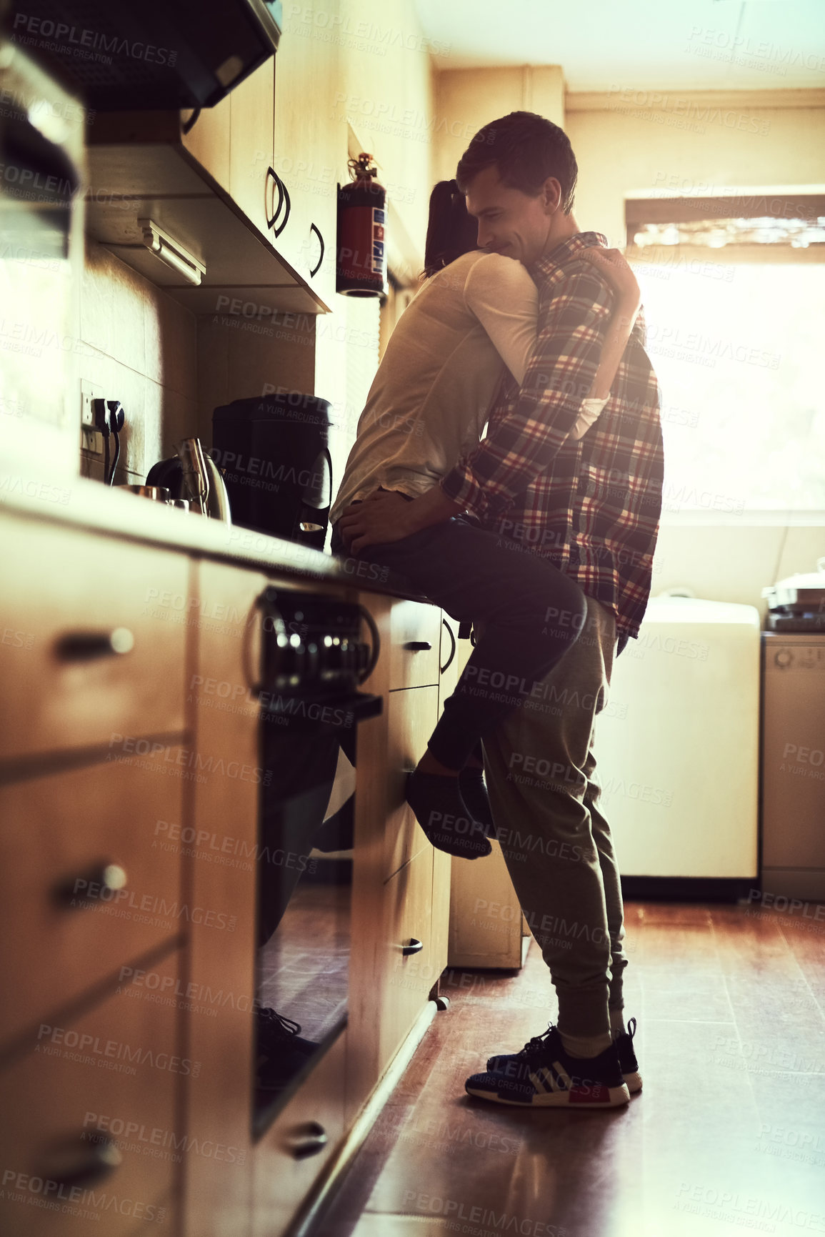 Buy stock photo Shot of an affectionate young couple sharing a romantic moment in the kitchen
