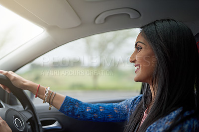 Buy stock photo Shot of an attractive young woman driving her car