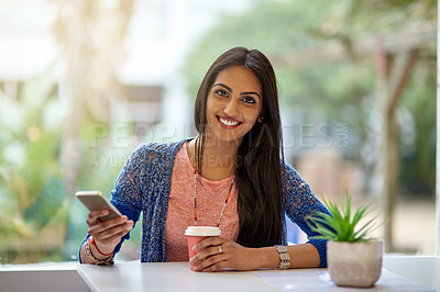 Buy stock photo Portrait of an attractive young woman using her cellphone while drinking coffee in a coffee shop