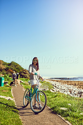 Buy stock photo Portrait of an attractive young woman riding her bicycle outside