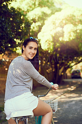 Buy stock photo Portrait of an attractive young woman riding her bicycle outside