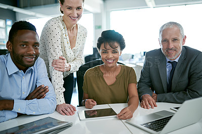 Buy stock photo Portrait of a group of smiling coworkers sitting at a desk in an office
