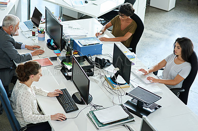 Buy stock photo High angle shot of a group of colleagues working on computers in an office