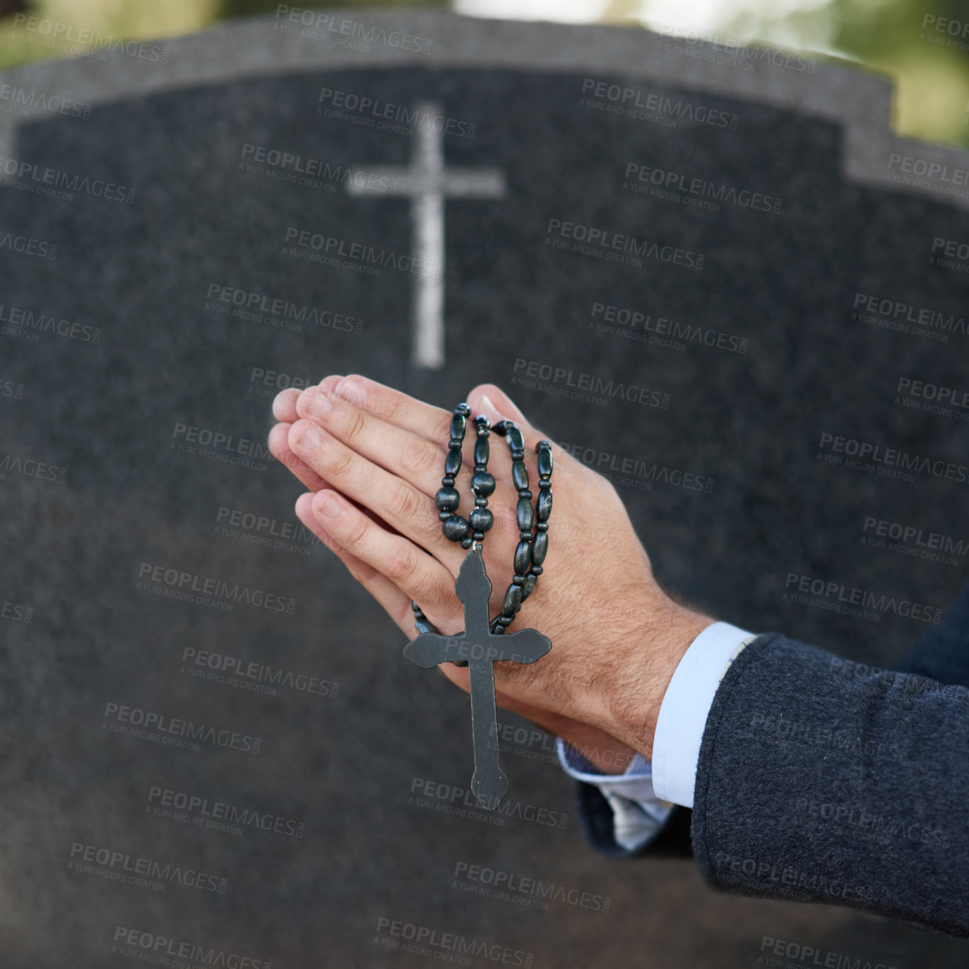 Buy stock photo Cropped shot of a man praying with a rosary at a gravesite