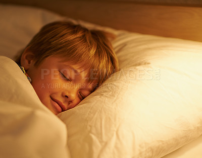Buy stock photo Boy, pillow and rest for night, sleeping and tired with fatigue and peace. Child, dreaming and exhausted with blanket, bed and bedroom with lamp for serene childhood at home or house for childcare