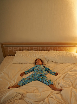 Buy stock photo Child, bed and rest for night, sleeping and tired with fatigue and peace. Boy, dreaming and exhausted with pyjamas, onesie and bedroom with lamp for serene childhood at home or house for calm kid