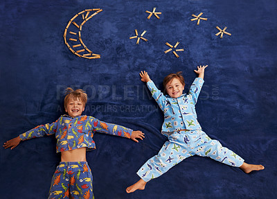 Buy stock photo Two young boys lying underneath an imaginary moon and stars