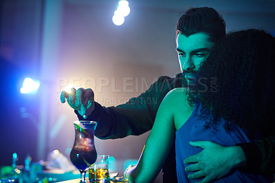 Buy stock photo Shot of a man spiking his partner's drink while she has her back turned