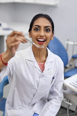 Buy stock photo Portrait of a young female dentist holding a surgical instrument