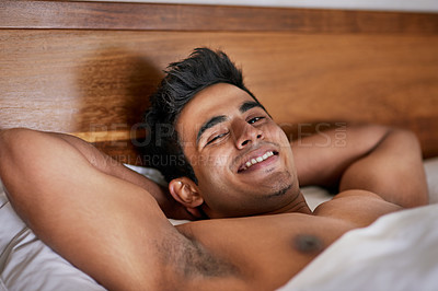 Buy stock photo Portrait of a happy young man waking up in bed feeling well rested
