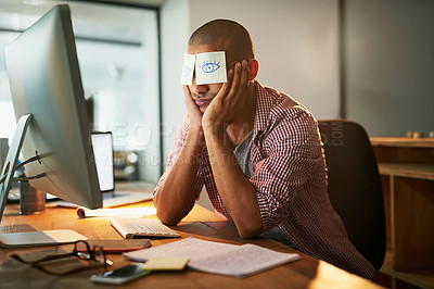 Buy stock photo Cropped shot of a young designer working late in an office with adhesive notes covering his eyes