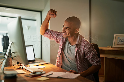 Buy stock photo Cropped shot of a young designer doing a fist pump while working late in an office