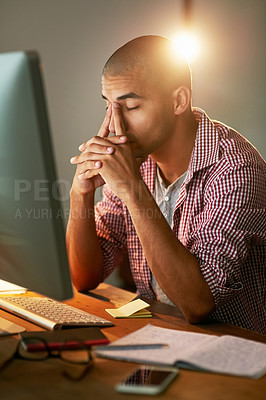 Buy stock photo Cropped shot of a young designer looking stressed out while working late in an office