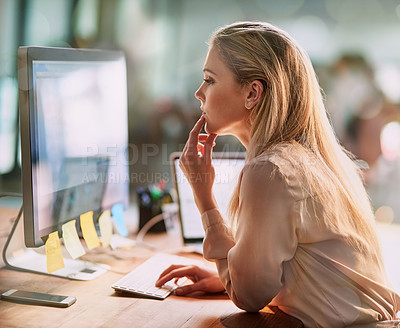 Buy stock photo Shot of a focused young businesswoman working on a computer in an office