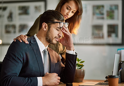 Buy stock photo Shot of a stressed out businessman being comforted while sitting at a table using a laptop
