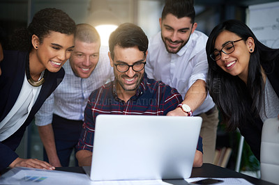 Buy stock photo Shot of a group of colleagues working together around a laptop in an office