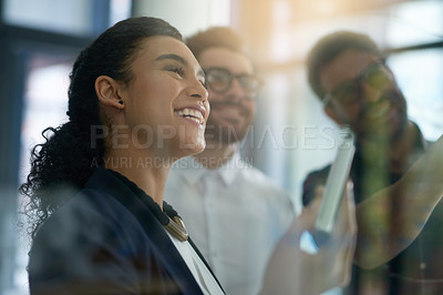 Buy stock photo Shot of a group of colleagues brainstorming together on a glass wall in an office