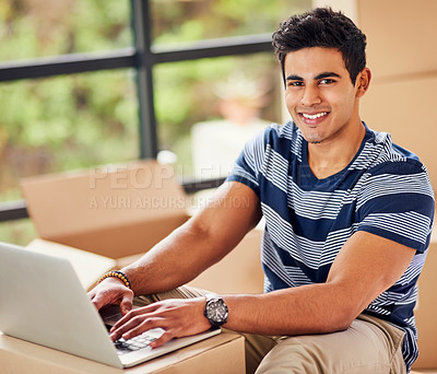 Buy stock photo Portrait of a young man using a laptop while taking a break from moving into a new home