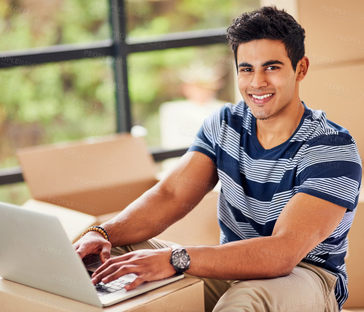 Buy stock photo Portrait of a young man using a laptop while taking a break from moving into a new home