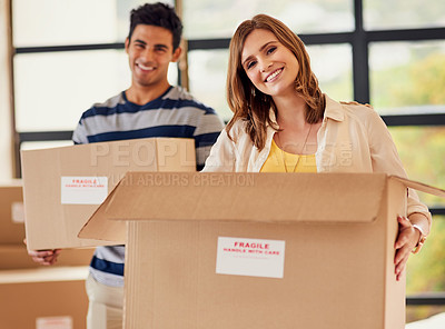 Buy stock photo Portrait of a smiling young couple carrying boxes on moving day