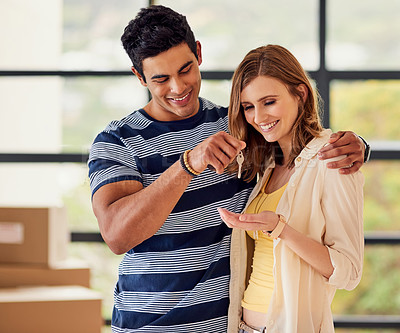 Buy stock photo Shot of a young mna giving the keys to their new home to his girlfriend on moving day