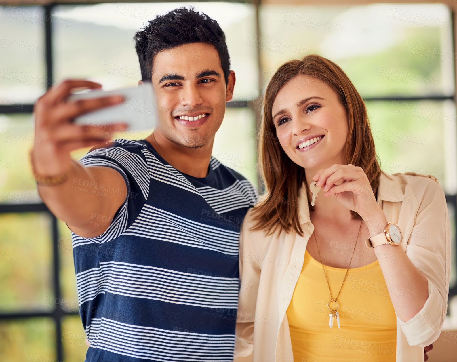 Buy stock photo Shot of a happy young couple taking a selfie together on their moving in day