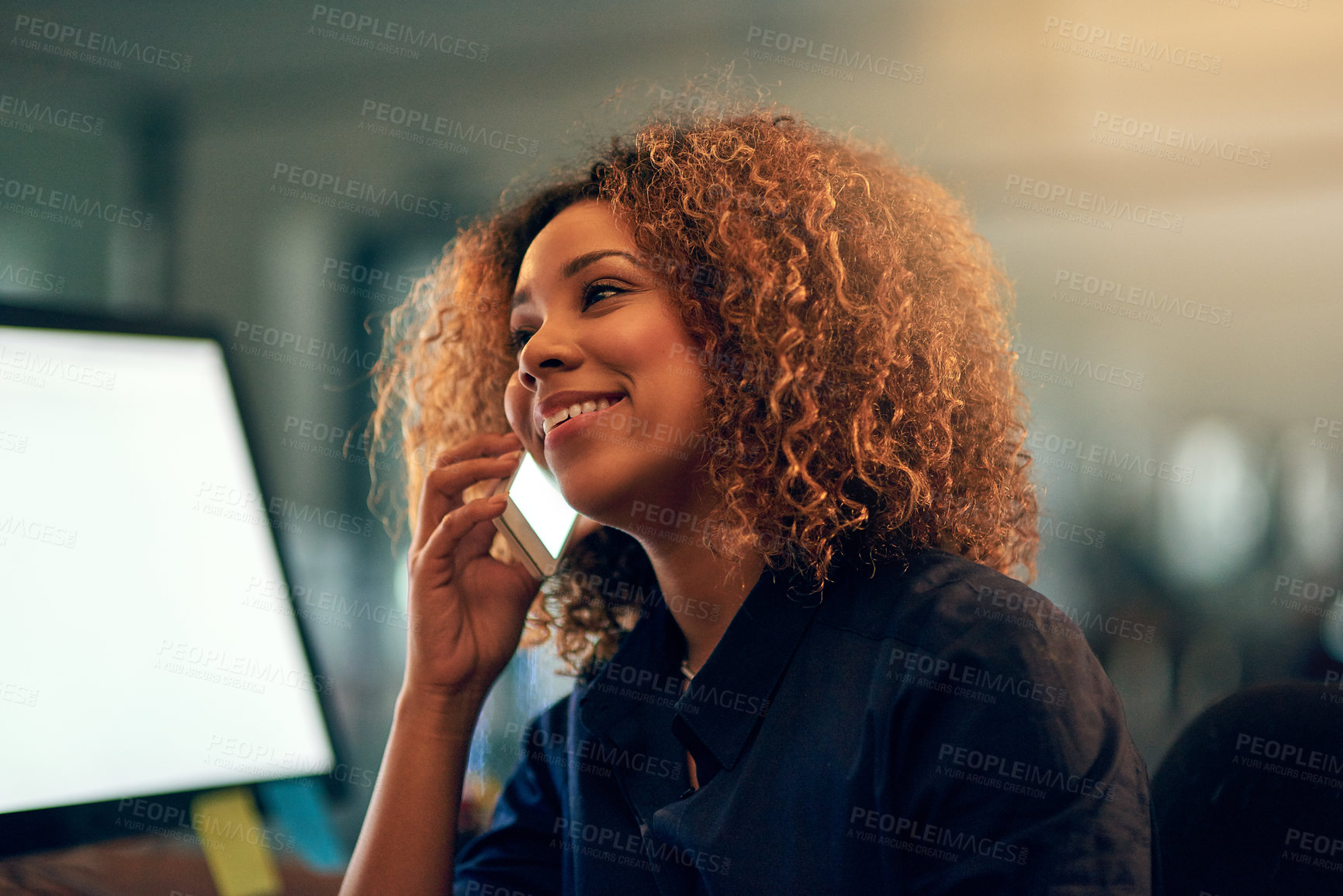 Buy stock photo Shot of a happy young businesswoman speaking on the phone during a late night at work