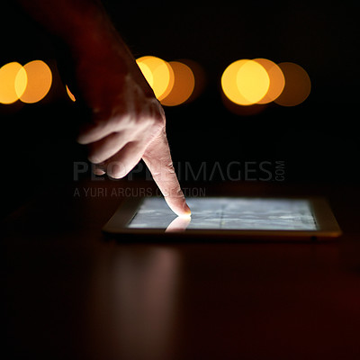 Buy stock photo Closeup shot of a person's finger using a digital tablet in the dark