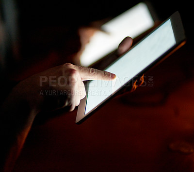 Buy stock photo Closeup shot of two people using digital tablets in the dark