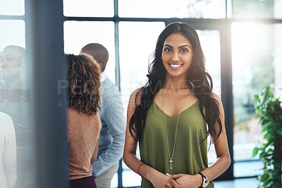 Buy stock photo Portrait of an attractive young woman standing in the office with her colleagues in the background