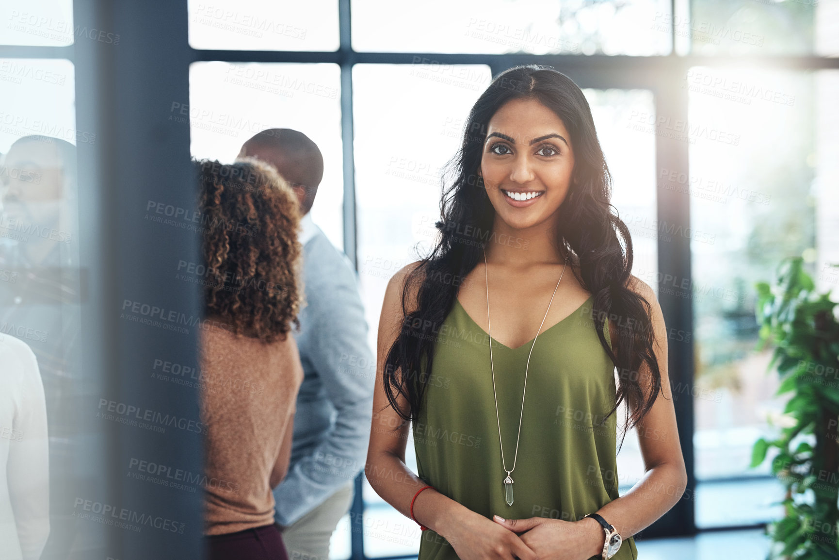 Buy stock photo Portrait of an attractive young woman standing in the office with her colleagues in the background